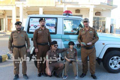 بالصور..طفل من ذوي الإحتياجات الخاصة يشارك مرور طريف توزيع المنشورات على المواطنين