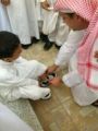 صورة الأمير فهد بن خالد يربط حذاء طفل يتيم تثير الإعجاب